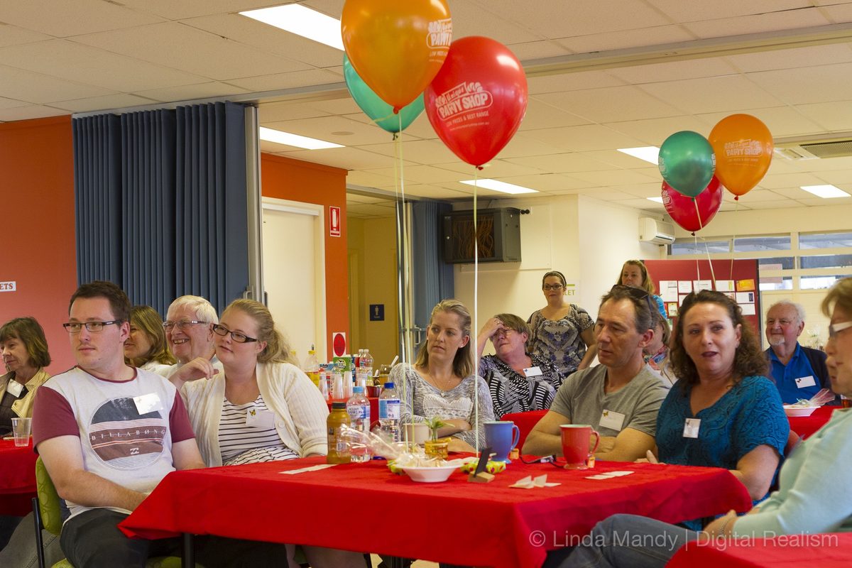 Locals around tables with balloons at a Dementia Awareness afternoon at the Hub