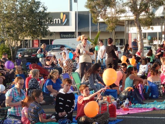 Families on picnic rugs at the drive-in movies